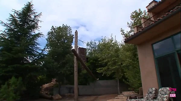 A woman with red hair wearing seductive undergarments receives a facial ejaculation while standing next to her husband, who enjoys seeing her engage in sexual activities with other men